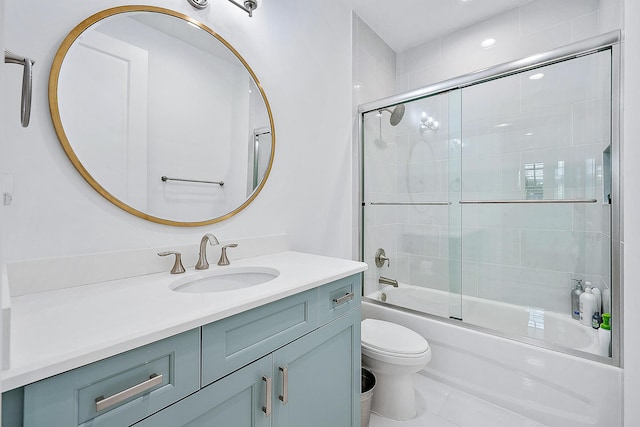 full bathroom featuring combined bath / shower with glass door, vanity, and toilet