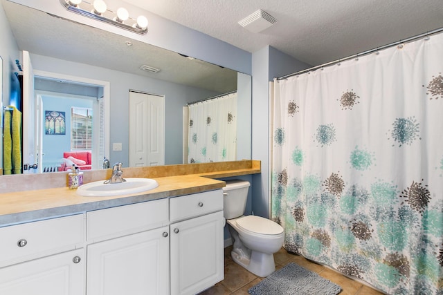 bathroom with toilet, a textured ceiling, tile patterned flooring, and vanity