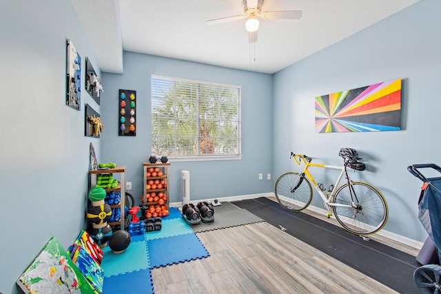 workout room featuring hardwood / wood-style flooring and ceiling fan