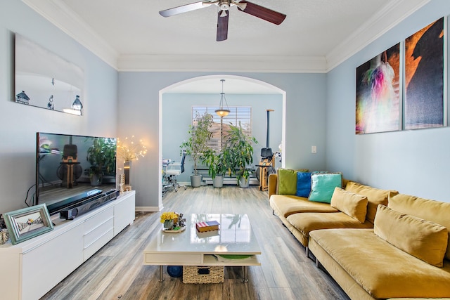 living room featuring wood-type flooring, ceiling fan, and ornamental molding