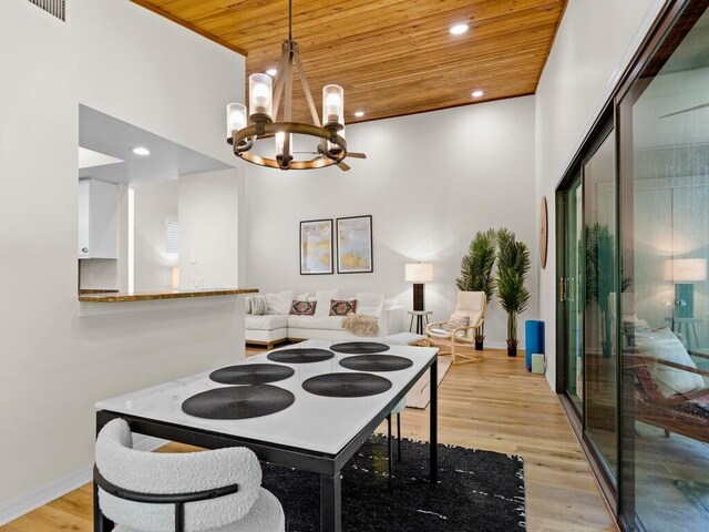 dining room featuring light hardwood / wood-style floors, a chandelier, and wooden ceiling