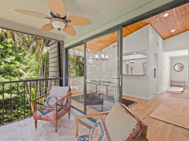 sunroom featuring wood ceiling, ceiling fan with notable chandelier, and vaulted ceiling