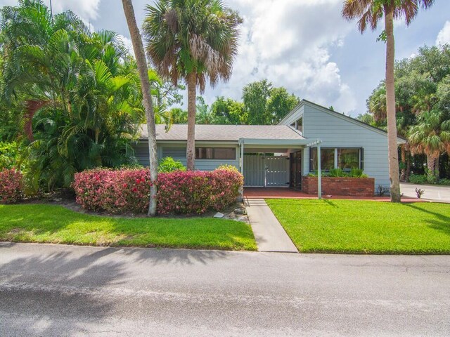 ranch-style home featuring a front yard and a carport