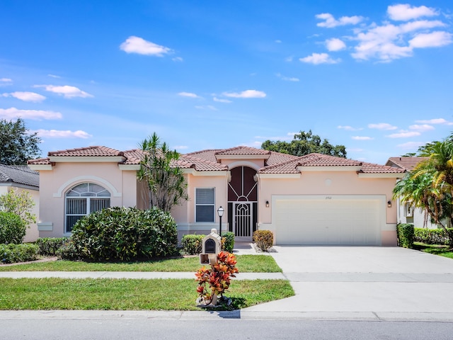 mediterranean / spanish house with a tile roof, concrete driveway, a garage, and stucco siding