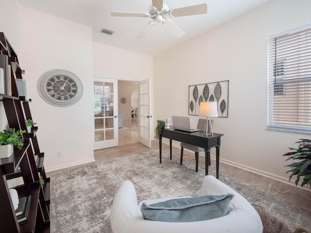 office space featuring french doors, light wood-type flooring, and ceiling fan