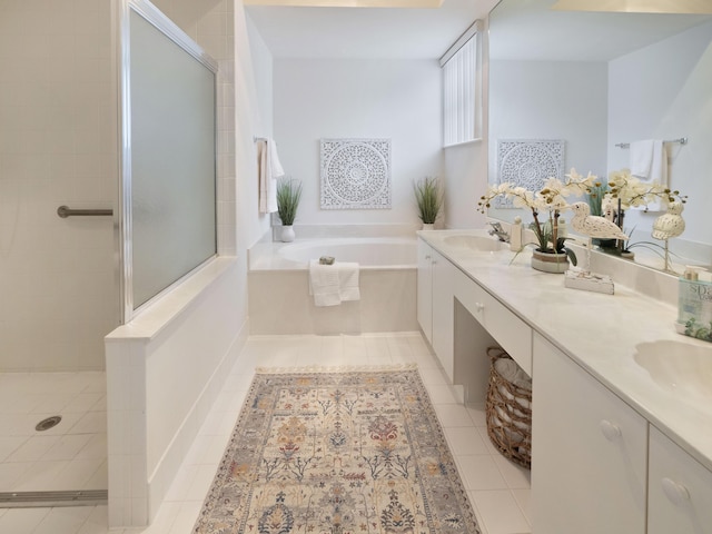 bathroom featuring tile patterned flooring, a sink, tiled shower, a bath, and double vanity