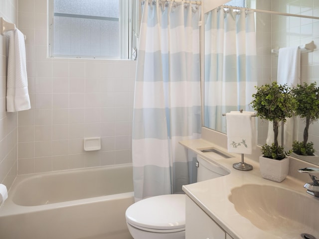 bathroom featuring vanity, toilet, and shower / bath combo with shower curtain