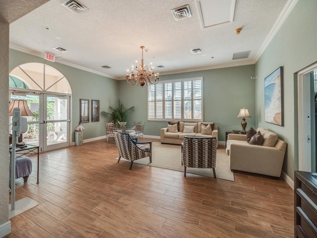 living room with a chandelier, a textured ceiling, hardwood / wood-style flooring, and a healthy amount of sunlight