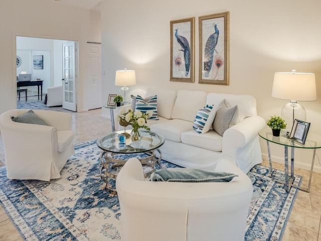 tiled living room featuring french doors and baseboards