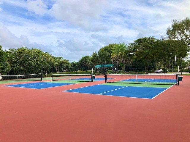 view of tennis court with community basketball court and fence