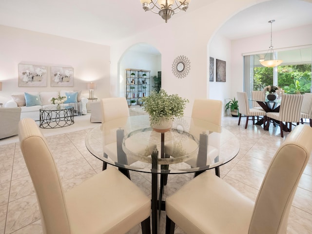 tiled dining room with a notable chandelier