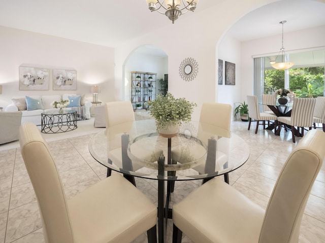 dining room featuring arched walkways and a chandelier