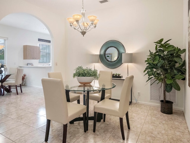 tiled dining room featuring a notable chandelier