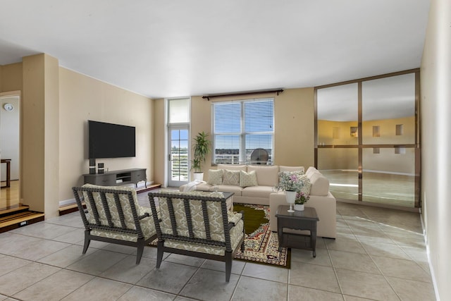 living room featuring a wall of windows and light tile patterned floors