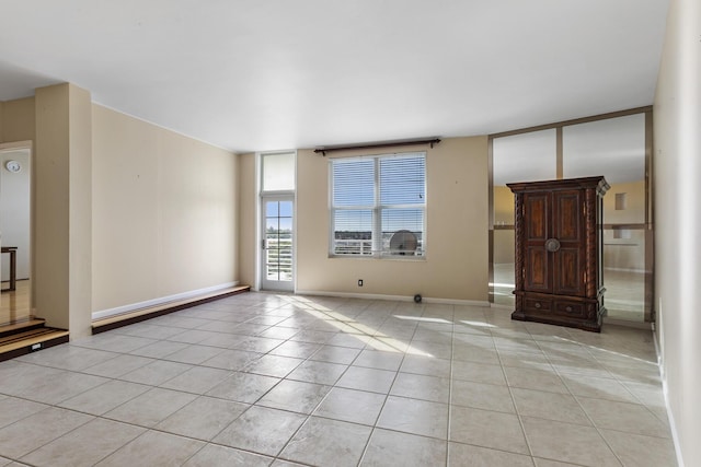 unfurnished room featuring baseboards and light tile patterned floors