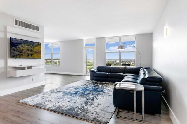 living area featuring wood finished floors, visible vents, and baseboards