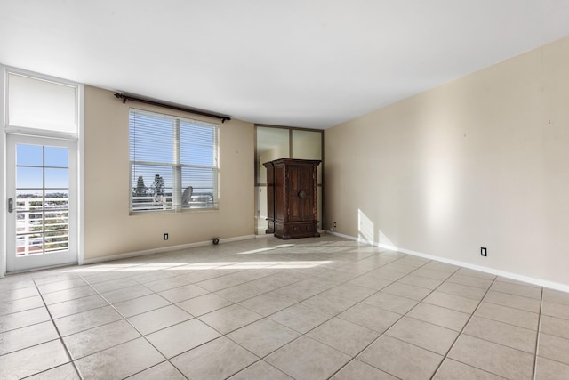 unfurnished room featuring light tile patterned floors, visible vents, and baseboards