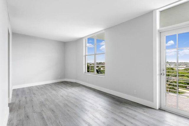 empty room featuring wood finished floors and baseboards