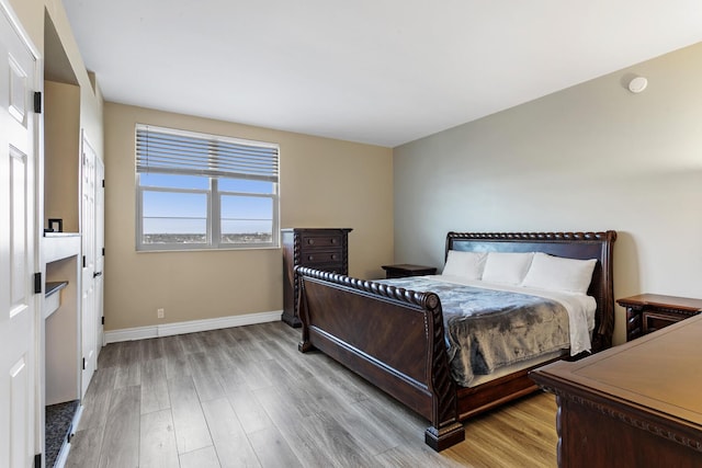 bedroom with light wood-type flooring and baseboards