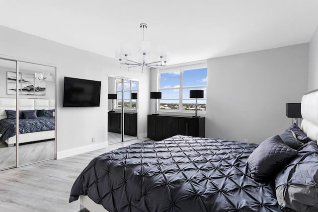 bedroom with baseboards, a chandelier, and wood finished floors