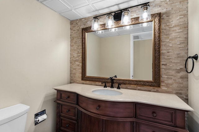 half bathroom featuring an ornate ceiling, visible vents, vanity, and toilet