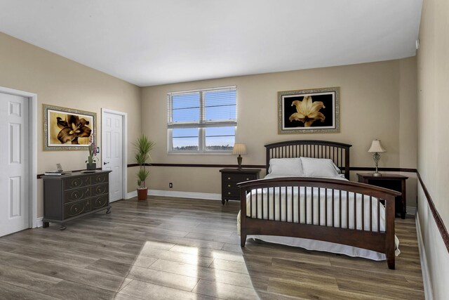 bedroom with baseboards and wood finished floors