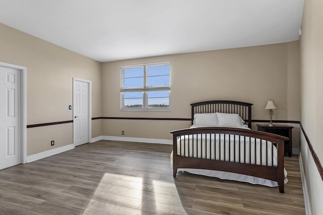 unfurnished bedroom featuring wood finished floors and baseboards