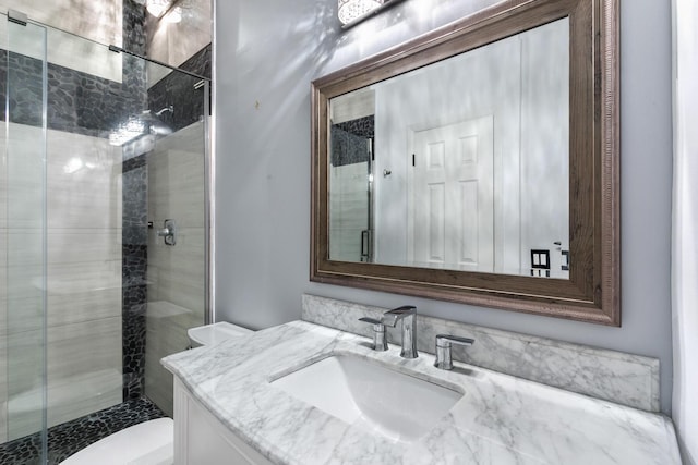 full bathroom featuring a shower stall, toilet, and vanity