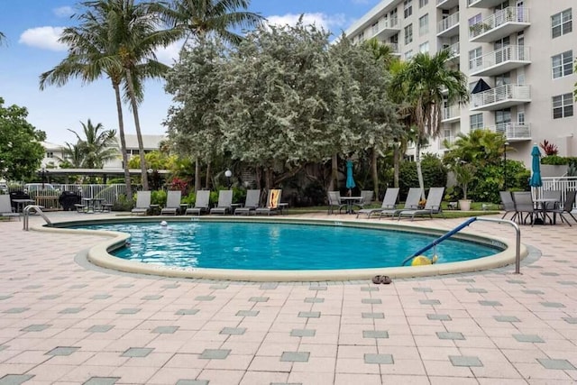 community pool featuring fence and a patio