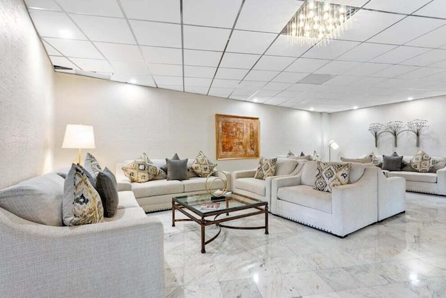 living room featuring marble finish floor and a drop ceiling