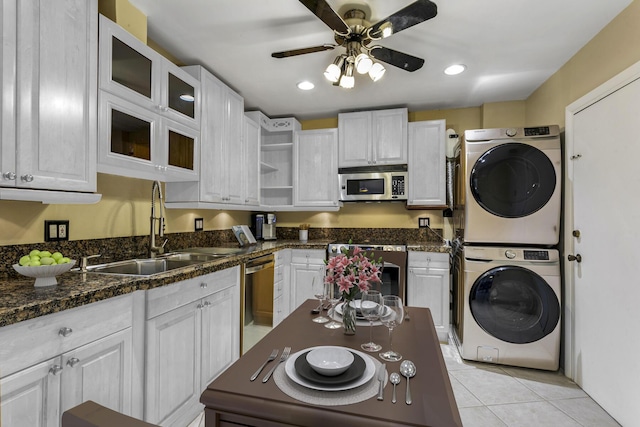 kitchen with stacked washer / dryer, stainless steel appliances, open shelves, a sink, and light tile patterned flooring