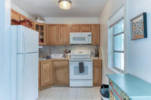 kitchen with white appliances, decorative backsplash, and light tile patterned flooring