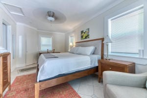 bedroom featuring crown molding, light tile patterned floors, and ceiling fan