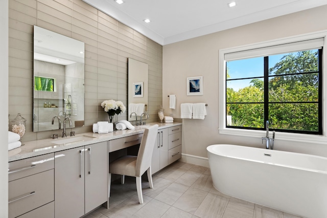 bathroom with vanity, tile walls, and a healthy amount of sunlight