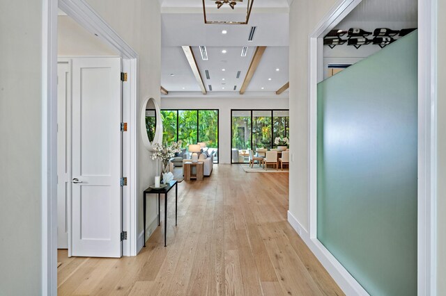 hall featuring light hardwood / wood-style flooring and beam ceiling