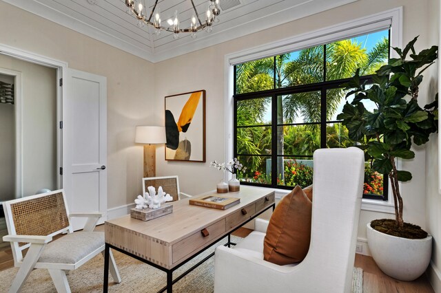 office with wood-type flooring, a notable chandelier, and a wealth of natural light