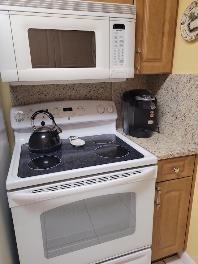 interior details with backsplash and white appliances