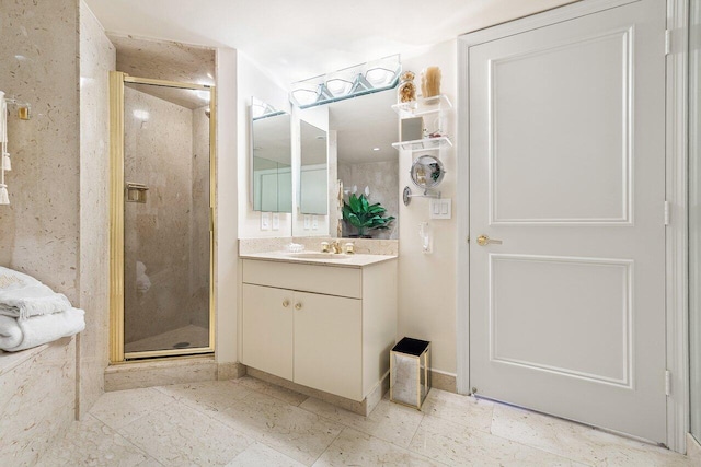 bathroom featuring a shower with door and vanity