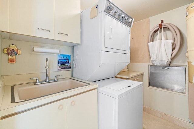 laundry room with stacked washer / dryer, cabinets, sink, and light tile patterned floors