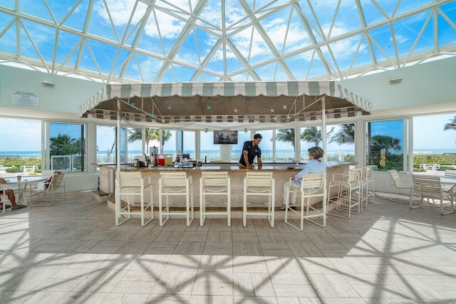 view of patio featuring a water view and exterior bar