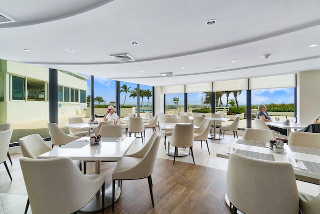 dining room featuring hardwood / wood-style floors, expansive windows, and plenty of natural light