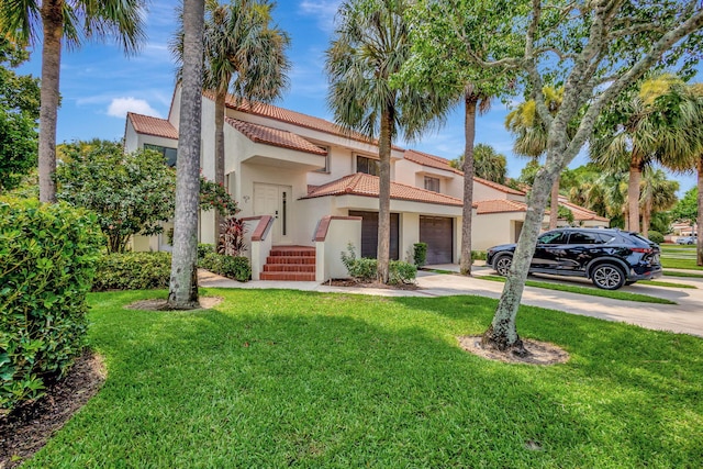 mediterranean / spanish-style house with a garage and a front yard