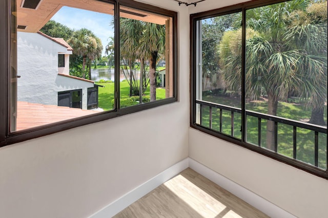 unfurnished sunroom featuring a water view