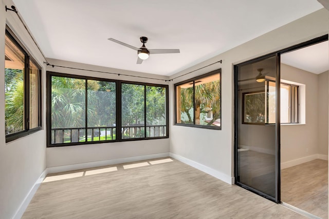 unfurnished sunroom featuring ceiling fan and plenty of natural light