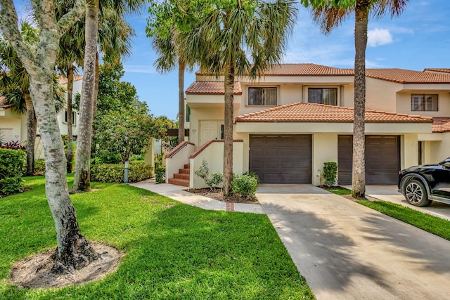 mediterranean / spanish-style house featuring a garage and a front yard