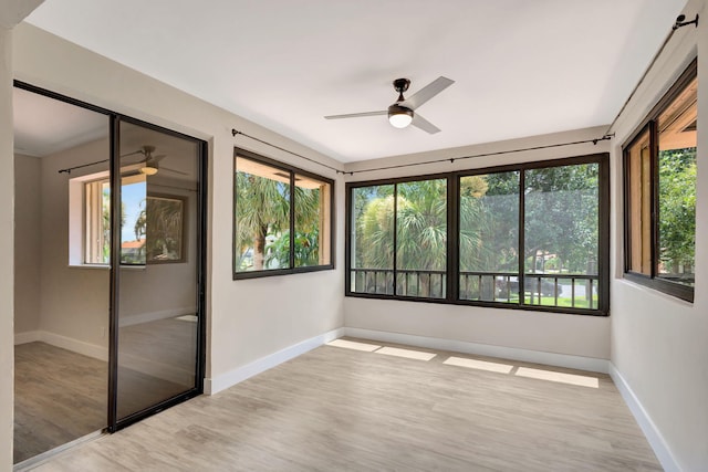 unfurnished sunroom with ceiling fan and a healthy amount of sunlight