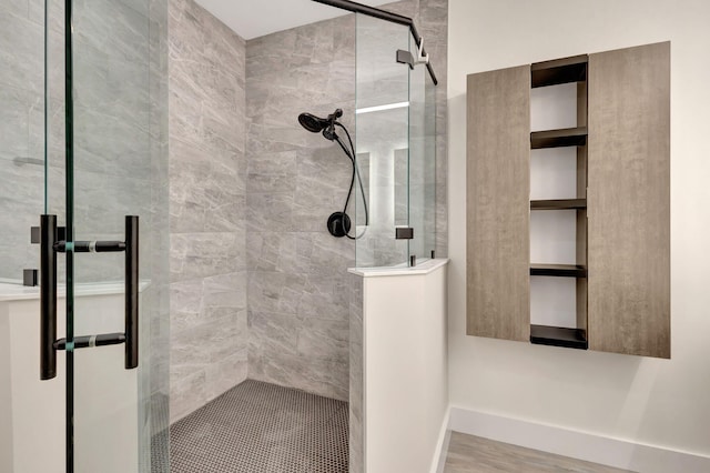 bathroom with a stall shower and baseboards
