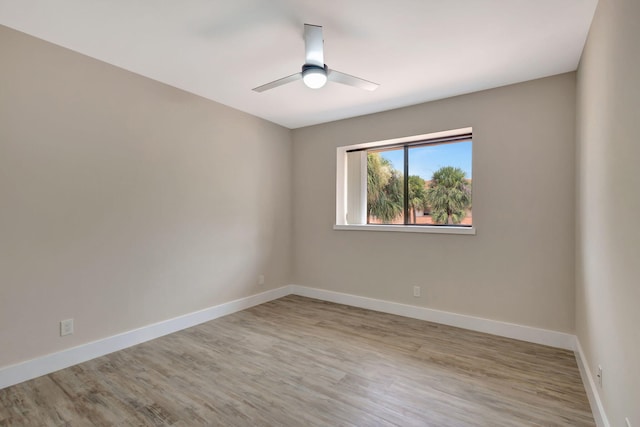 spare room featuring light wood-style floors, baseboards, and ceiling fan