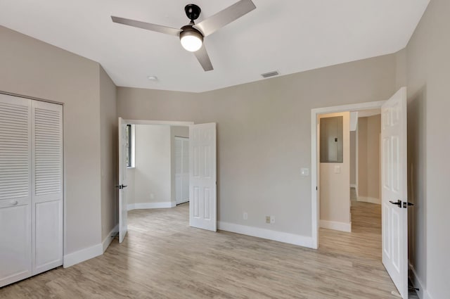 unfurnished bedroom featuring ceiling fan, a closet, and light wood-type flooring