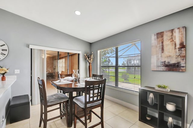 tiled dining room with lofted ceiling